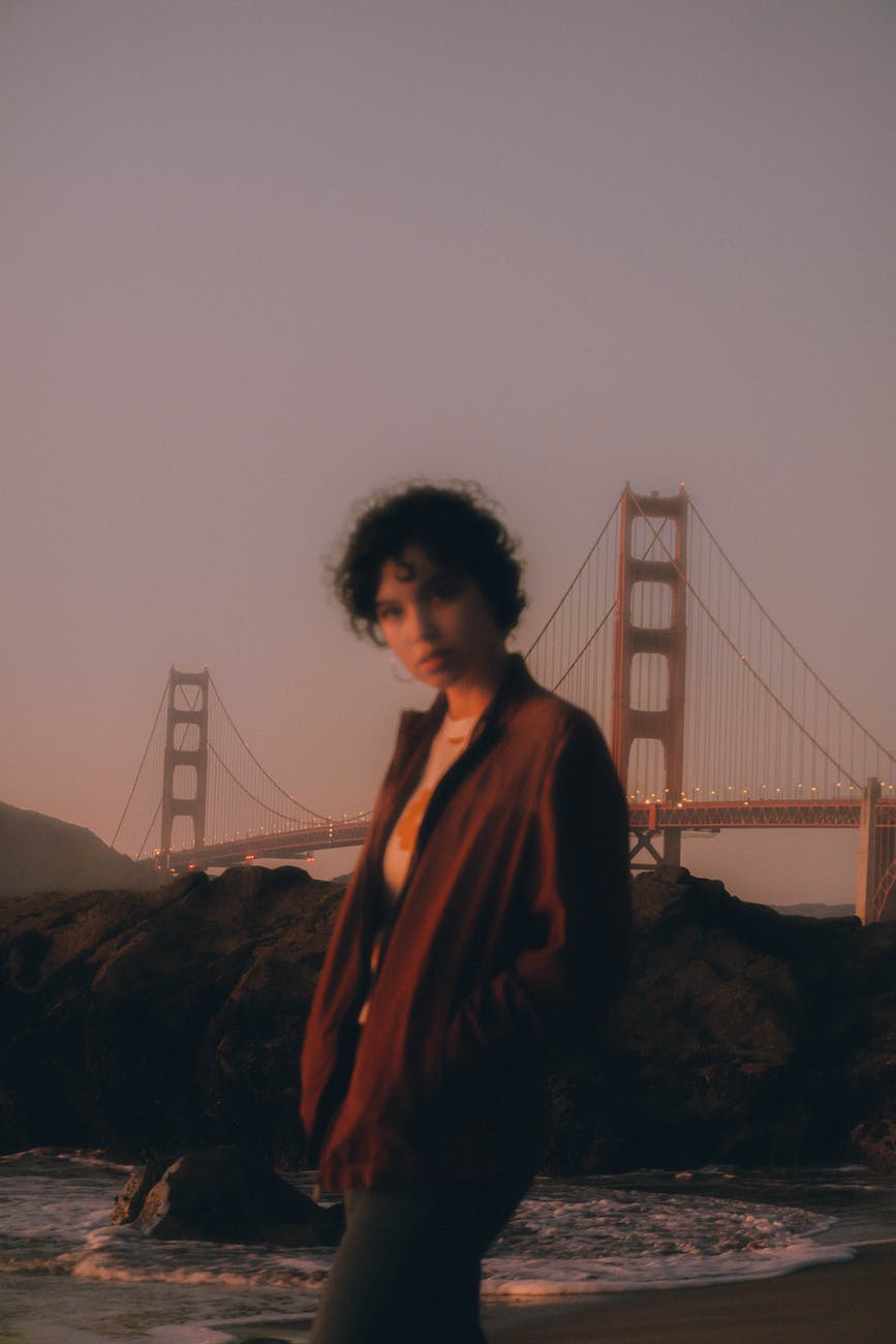 woman standing on seashore near golden gate bridge